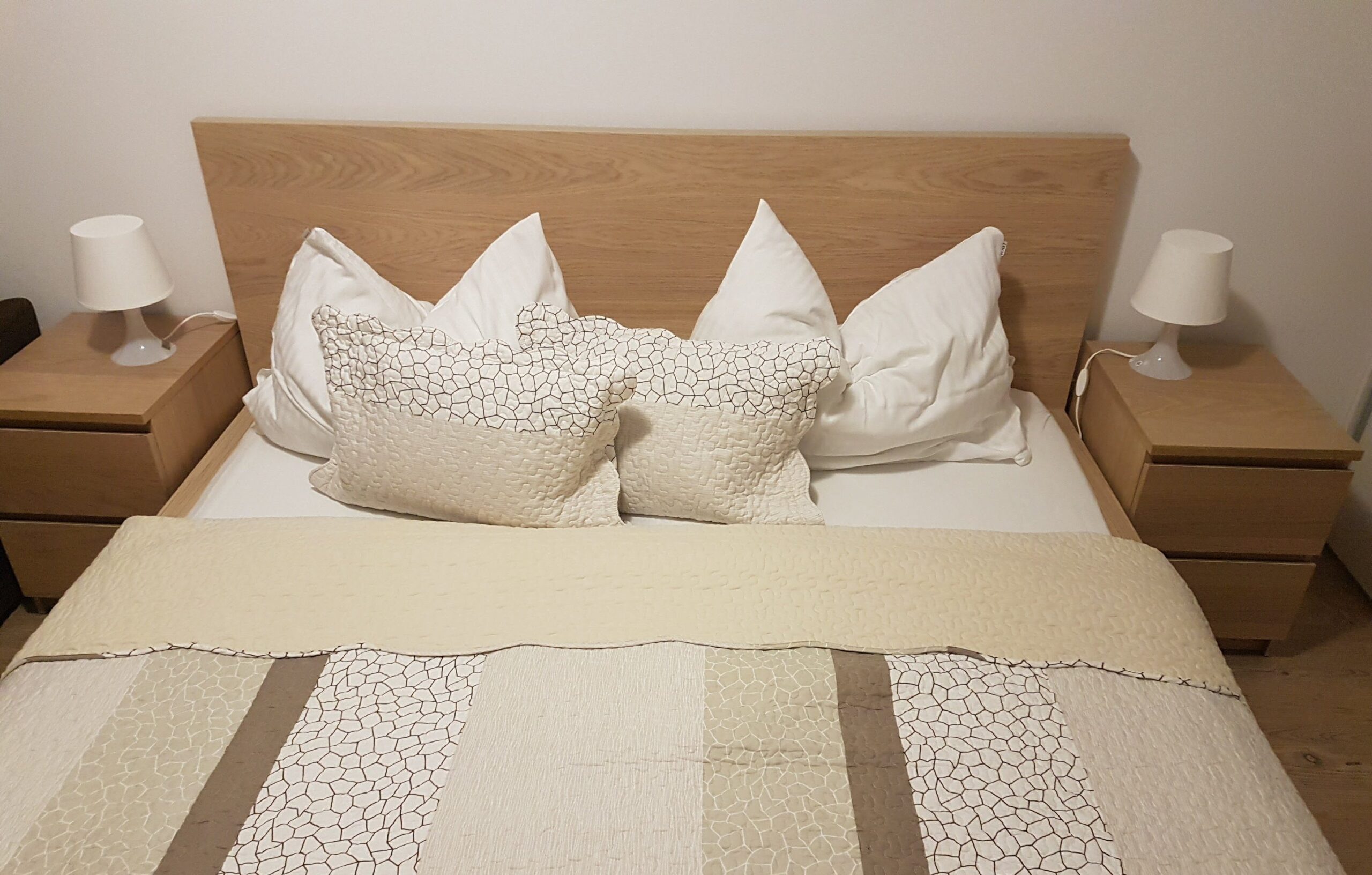 Spálňa s manželskou posteľou v apartmánoch Malý Princ, Bojnice, Slovensko. Bezúčelne zariadená spálňa s vankúšmi a vankúšom.