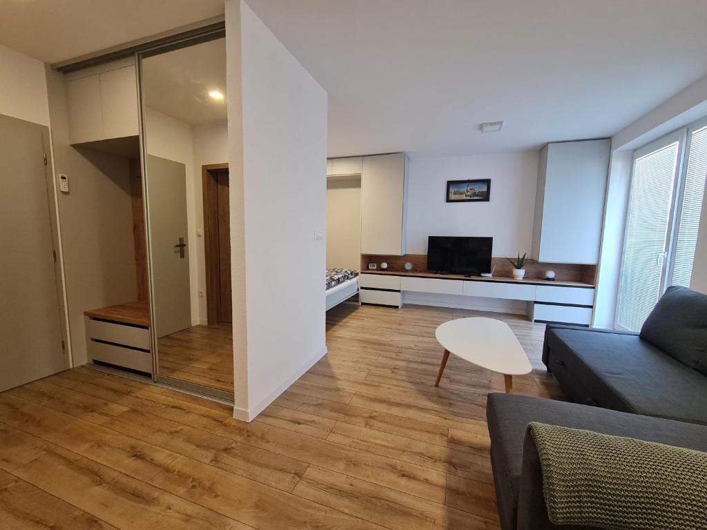 Moderná obývačka apartmánu s televízorom a sivou sedačkou - ubytovanie apartmány Malý Princ Bojnice Slovensko